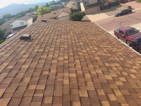 Aerial view of a completed asphalt shingle roof replacement in Colorado