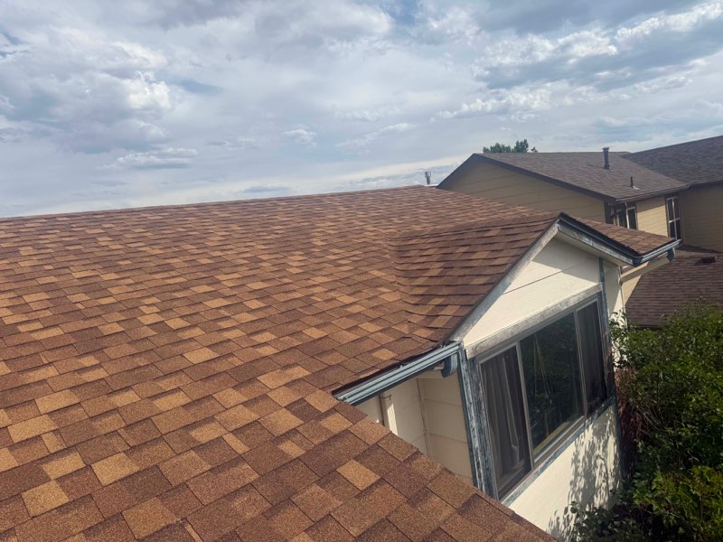 Completed shingle roof with dormer and new gutter line
